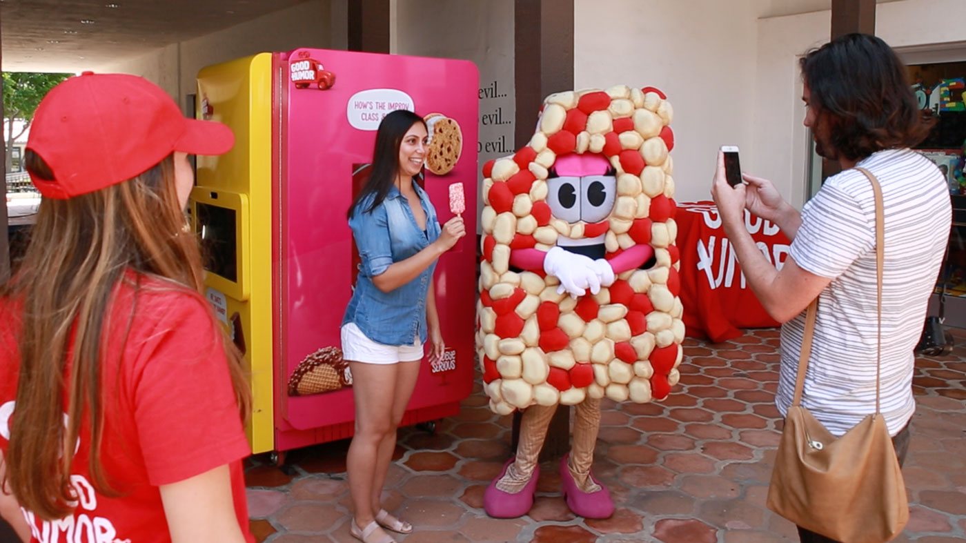 Guest posing with the Good Humor mascot next to the pink vending machine
